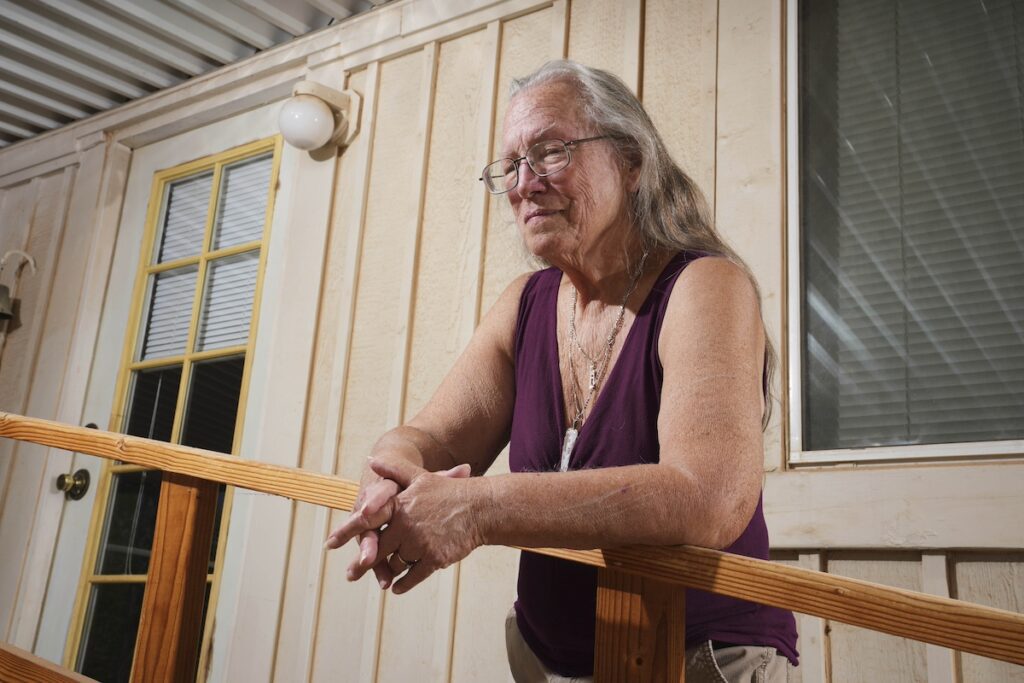 older woman standing on porch
