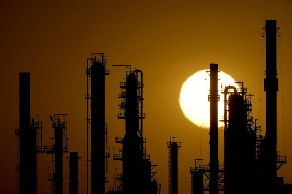 The CHS oil refinery is silhouetted against the setting sun